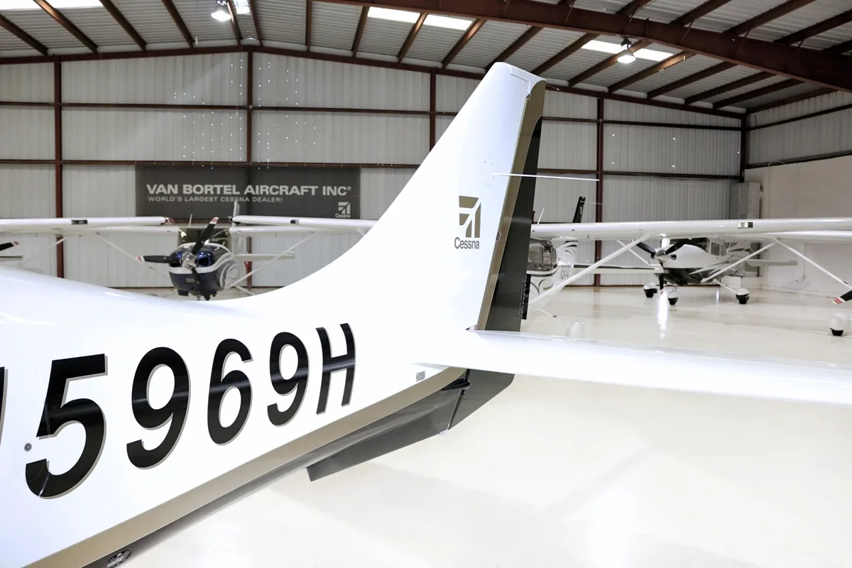 A close-up of the tail of the aircraft, showing the registration N5969H and a Cessna logo, in a hangar.