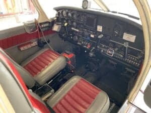 View of the aircraft cockpit from the side, showing the instrument panel and seats.