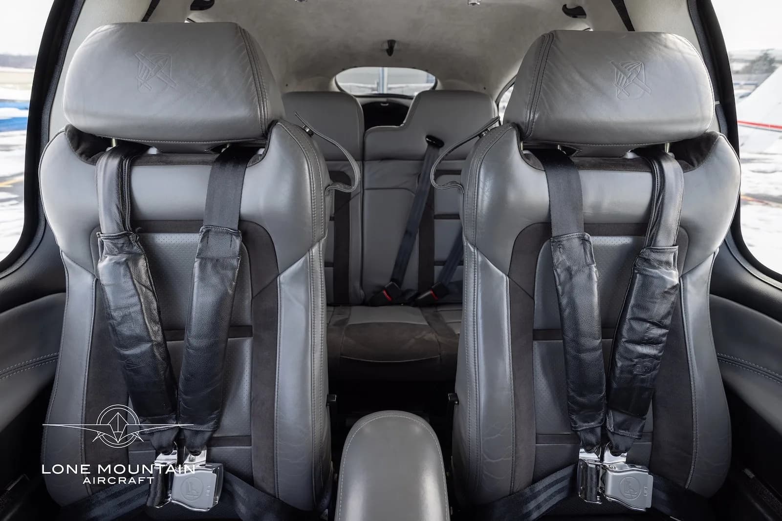 The gray leather and fabric interior seats of the Cirrus SR20 cabin, viewed from the front.