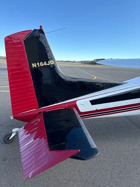 Close-up of the tail section of a Cessna 185 Skywagon, displaying the registration number N164JD.