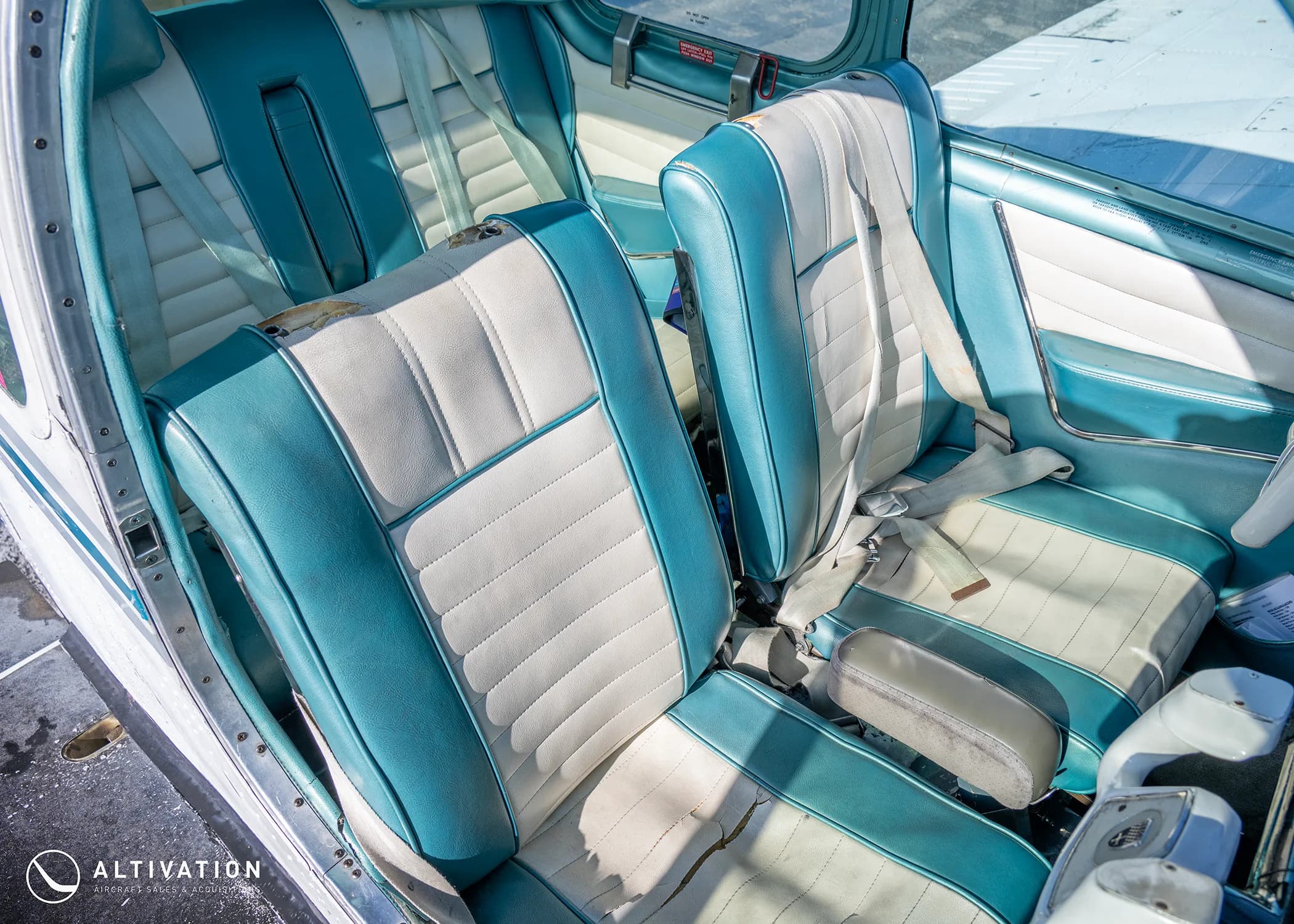Close-up view of the teal and white upholstered seats in the aircraft's cabin.