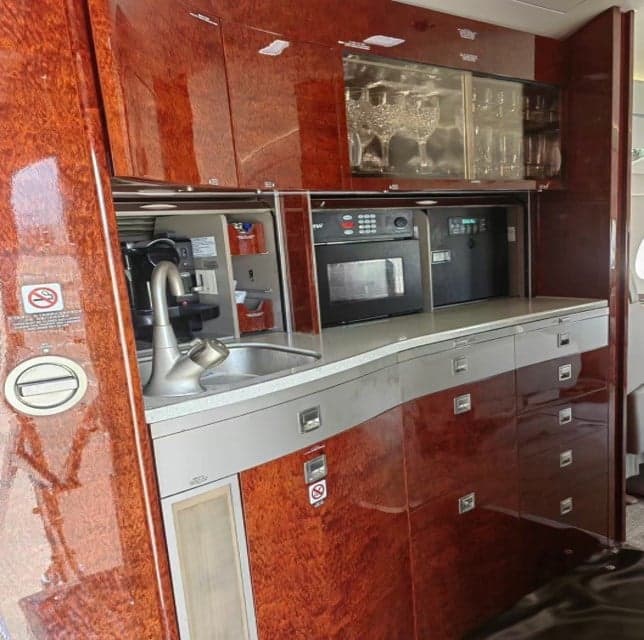 Galley area with sink, microwave, and storage in the aircraft interior.