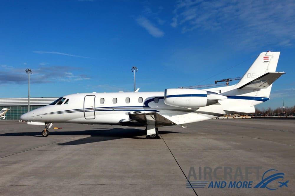 A white and blue jet aircraft parked on the tarmac.