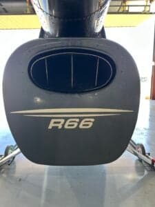 A close-up of the tail of the Robinson R66 helicopter shows the R66 logo.