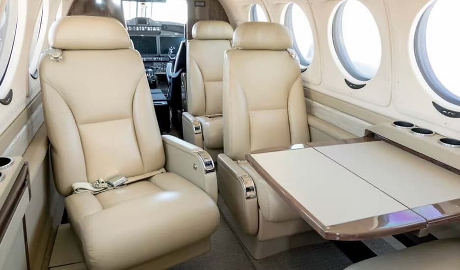 View of the aircraft's interior with leather seats and a table.
