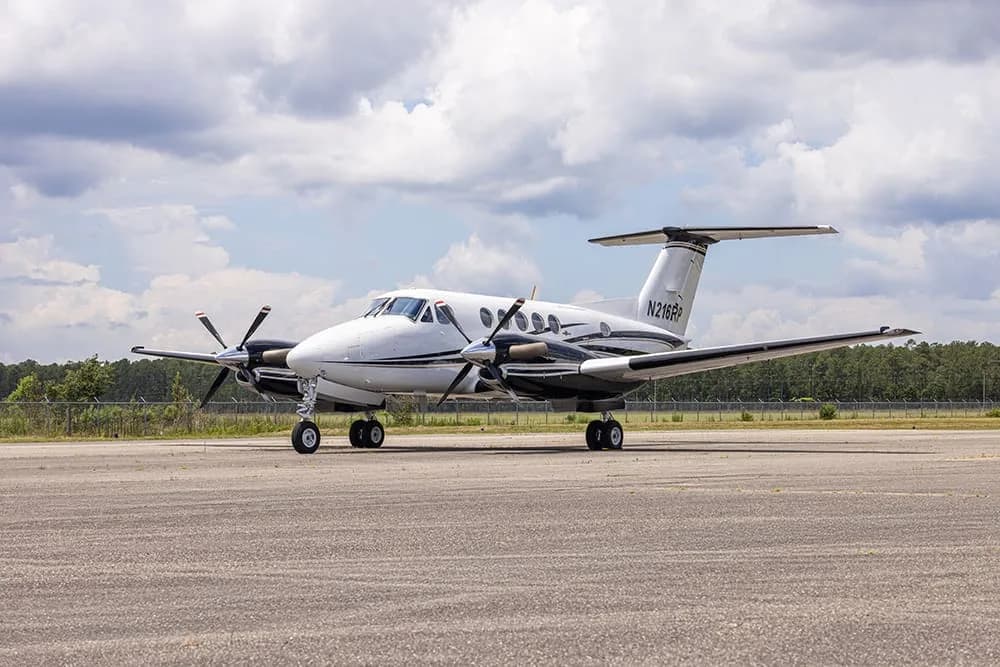 A King Air aircraft with registration N216RP is parked on the tarmac.