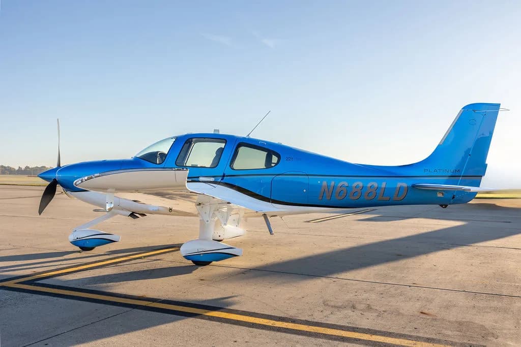 A side view of a blue and white Cirrus SR22 aircraft with registration N688LD on an airfield.