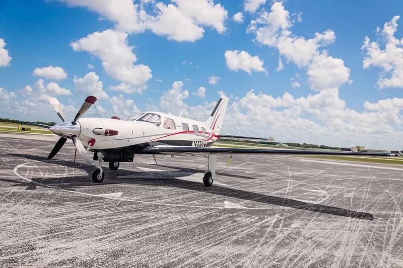 A turboprop aircraft on the tarmac with a white and red paint scheme.