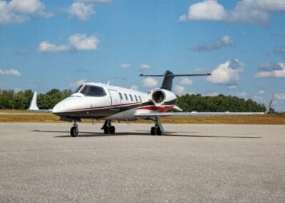 A Learjet 45XR aircraft is parked on the tarmac on a sunny day.