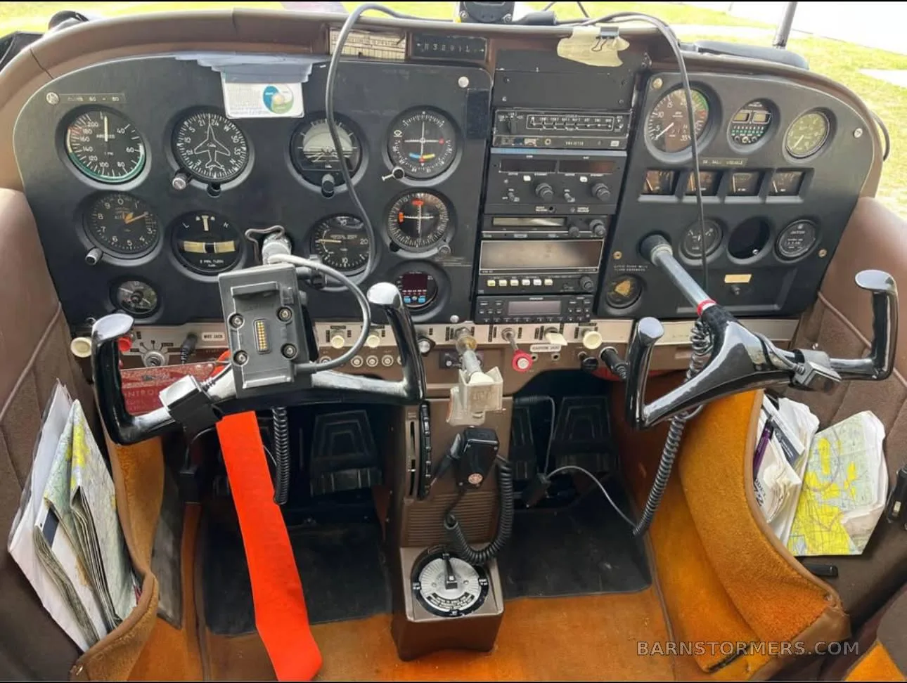 The cockpit of a small aircraft, showing the instrument panel, yokes, and avionics.