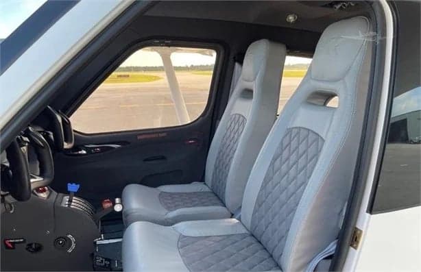View of the aircraft's interior with gray leather seats.