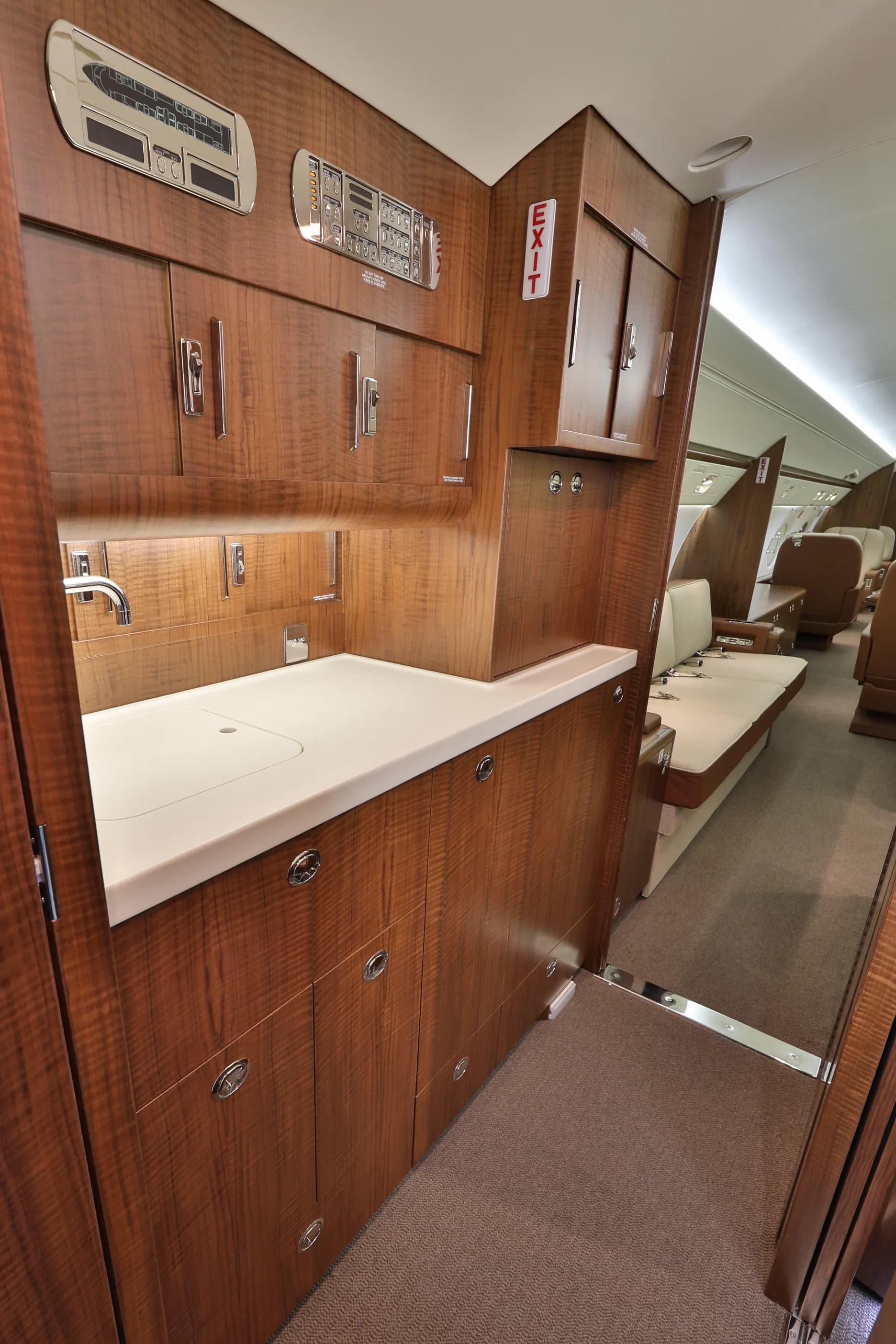 View of the aircraft's interior with a sink and wood cabinets.