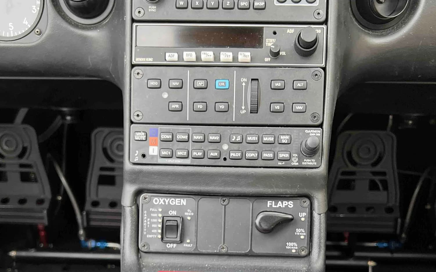 A close-up view of the lower center console of a Cirrus SR22 cockpit, showing radio and control panels.