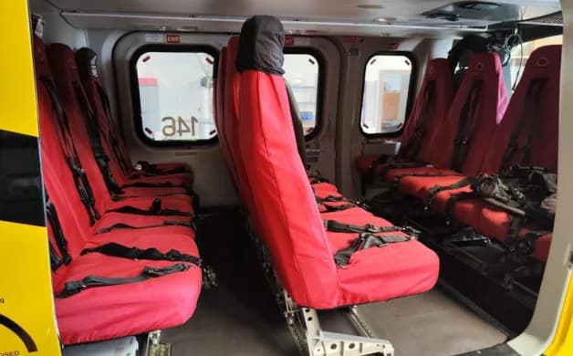 Interior view showing red cabin seats of the helicopter.