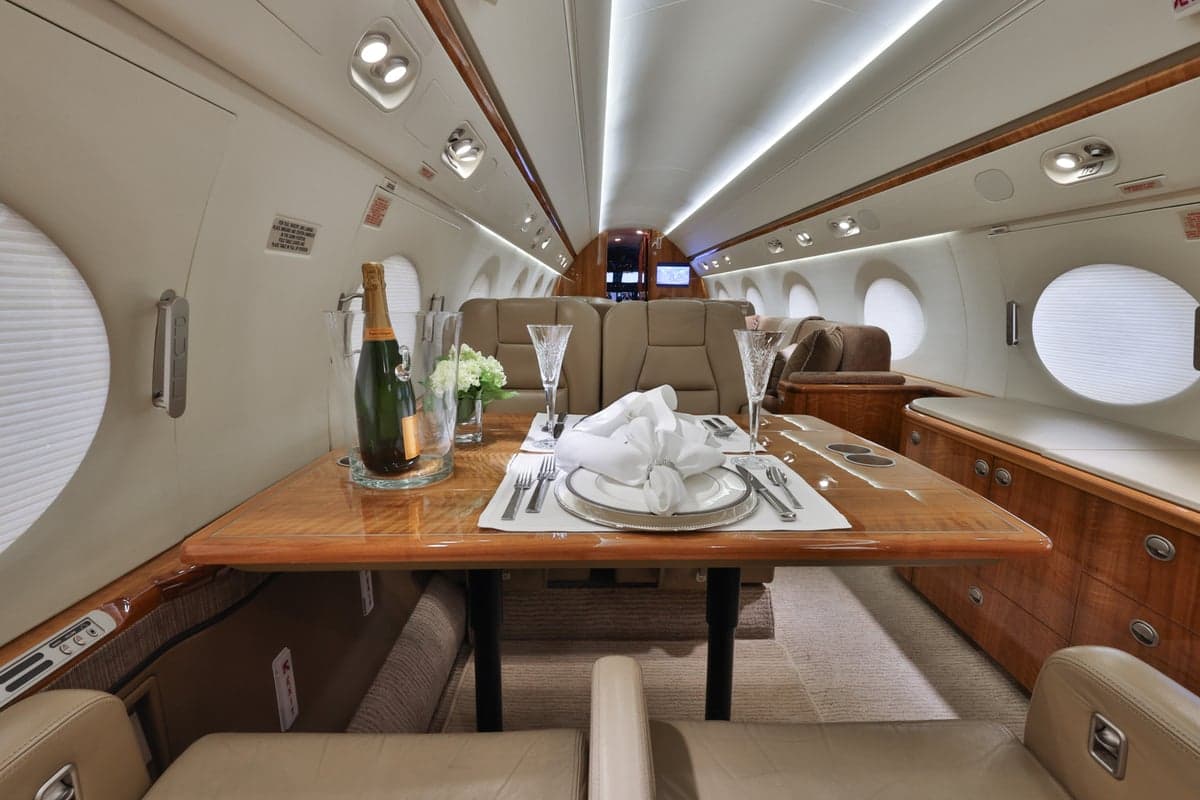 Interior view of the aircraft cabin with a dining table set for a meal.