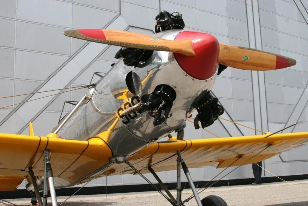 Close-up of a biplane with a polished fuselage and yellow wings.