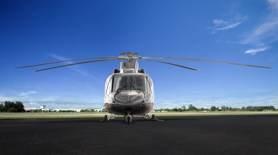 Front view of a silver AgustaWestland AW139 helicopter on the tarmac.