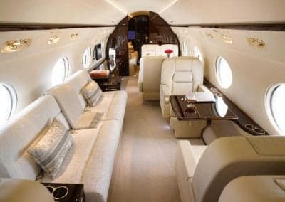 Aircraft interior featuring cream-colored seats and a sofa.