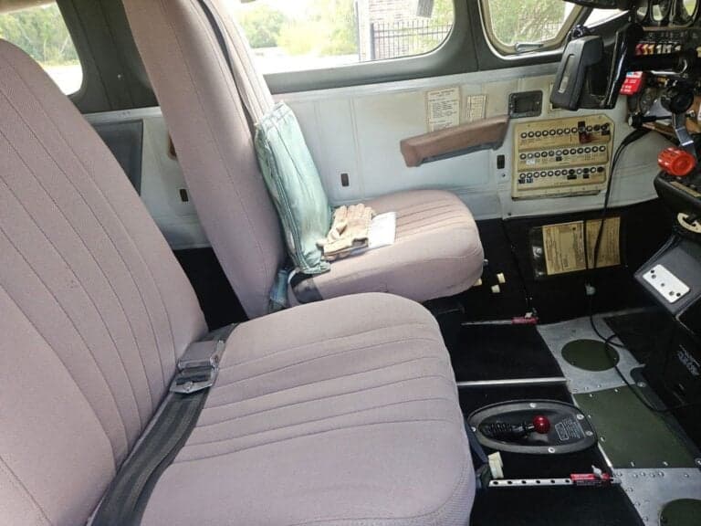 A view of the aircraft's interior, including seats and side panel controls.
