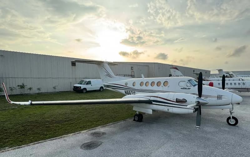 A King Air 200 aircraft with registration N66TG parked on the tarmac at sunset.