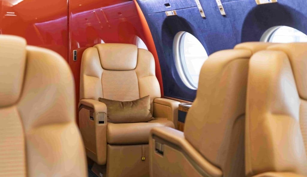A view of the aircraft's cabin with tan leather seats and blue walls.