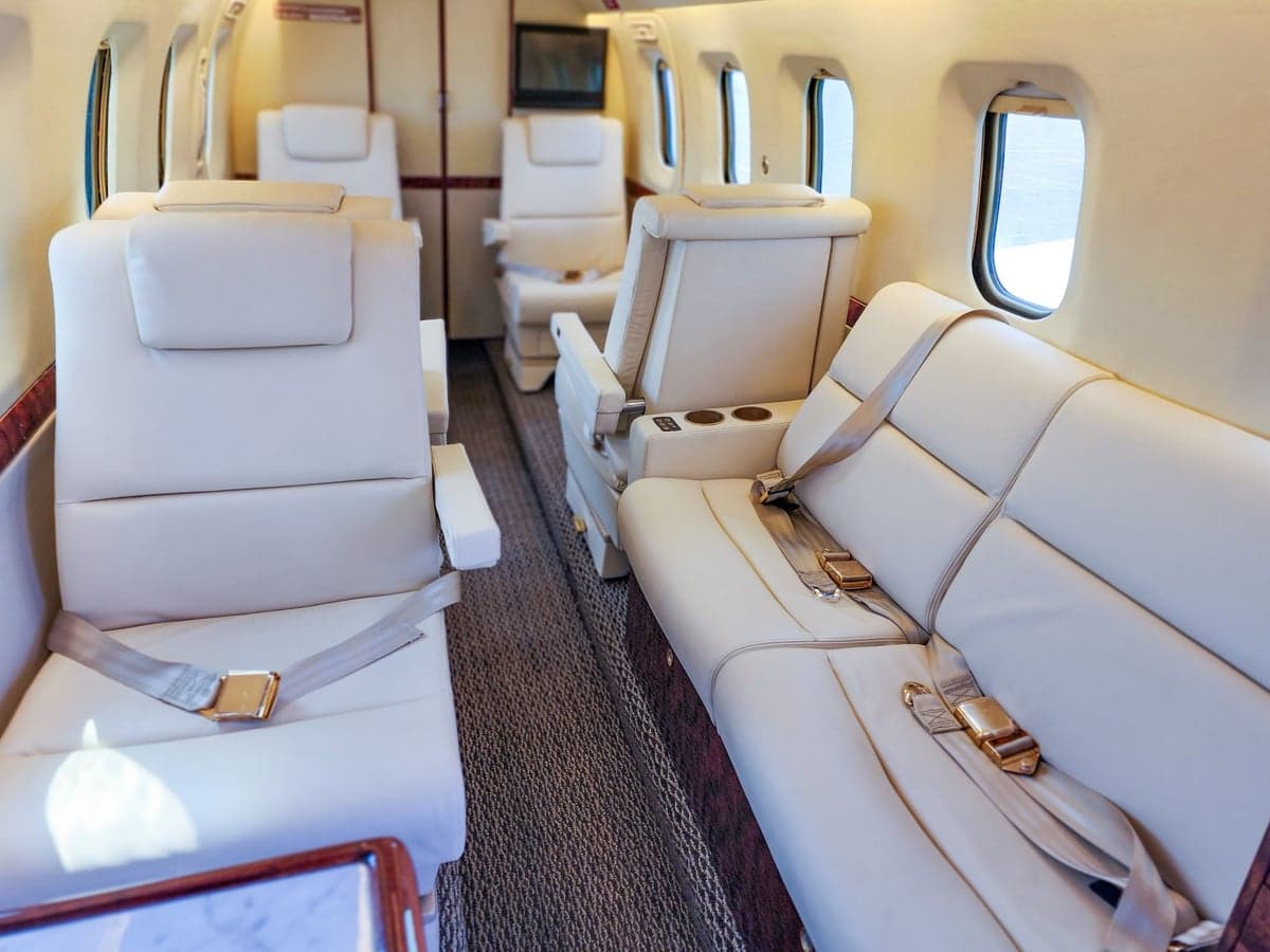 Overhead view of the aircraft cabin with white leather seats.