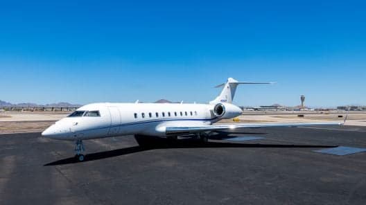 Bombardier Global Express with the airstair door open at dusk.