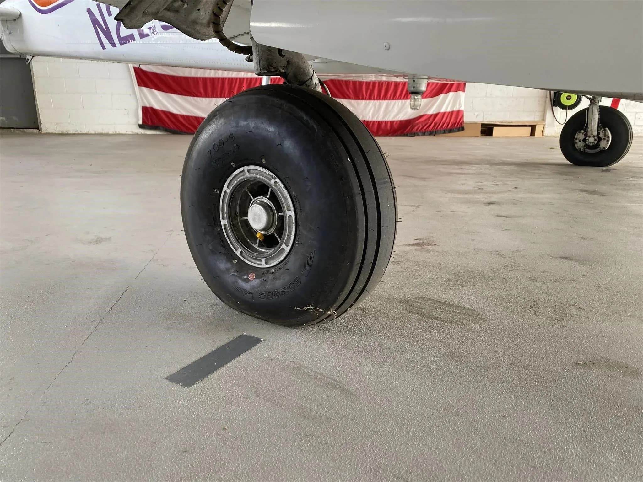 A close-up view of the main landing gear wheel of the Piper Aztec aircraft.