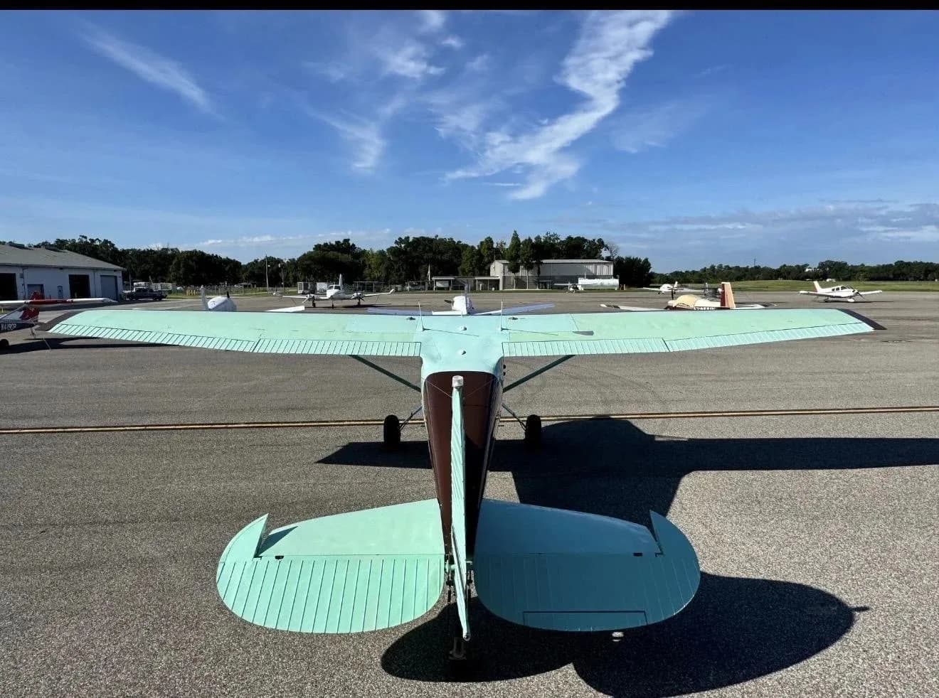 A direct rear view of a brown and light green Cessna 170B (N1881C) parked on an airport tarmac.