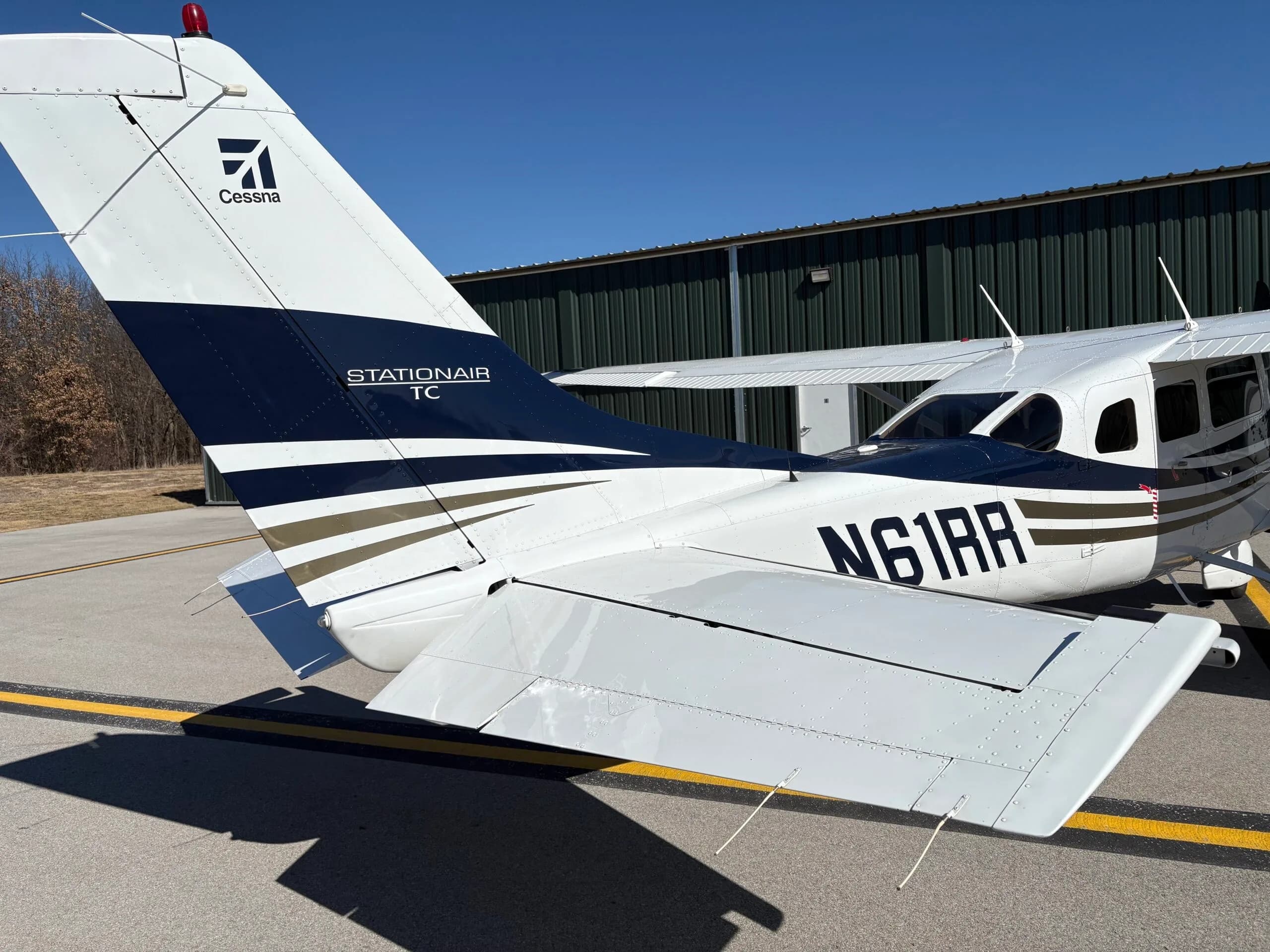 Close-up of the tail section of a white and dark blue Cessna Stationair TC aircraft with registration N61RR.