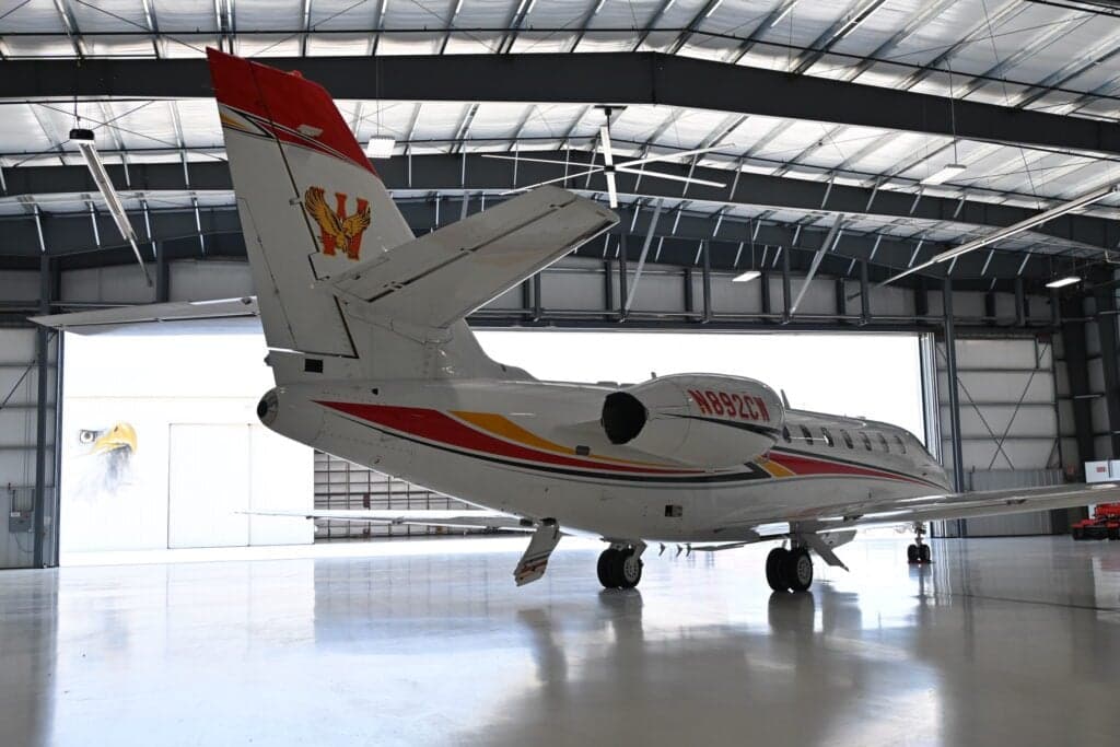 Rear quarter view of a Citation Sovereign aircraft with tail number N892CW in a hangar.