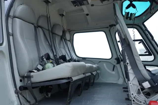 The grey passenger seats in the cabin interior of a helicopter.