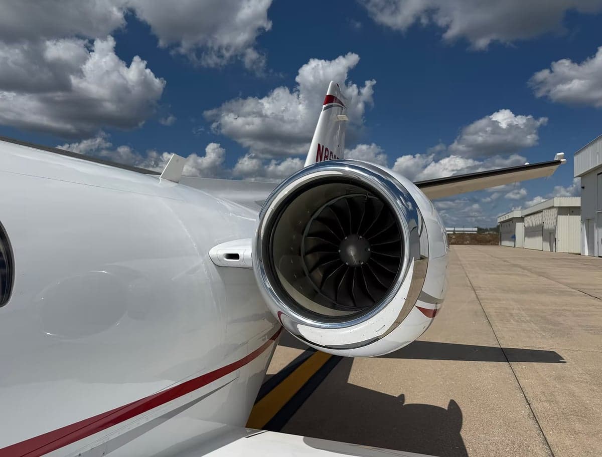 Close up of a jet engine and tail with registration number.