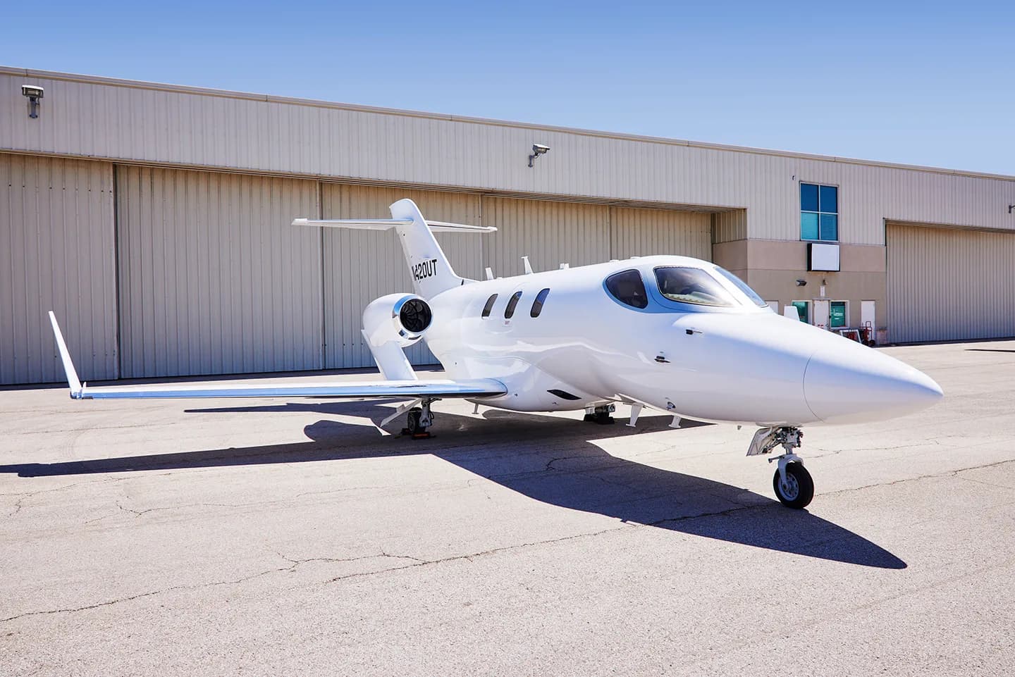 Side view of a white HondaJet N420UT on the tarmac.