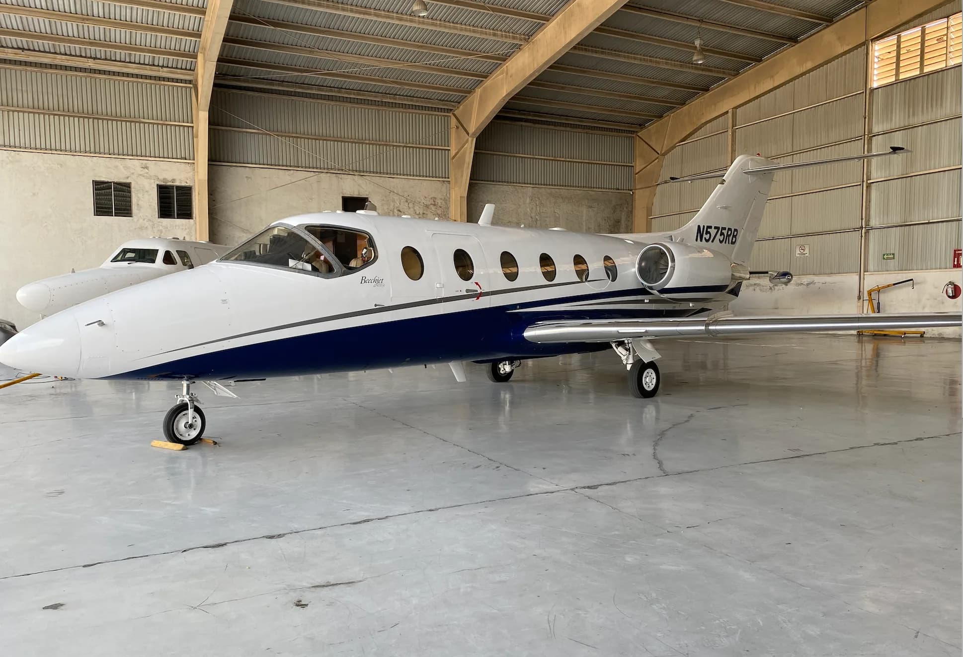 A white and blue jet with tail number N575RB parked in a hangar.