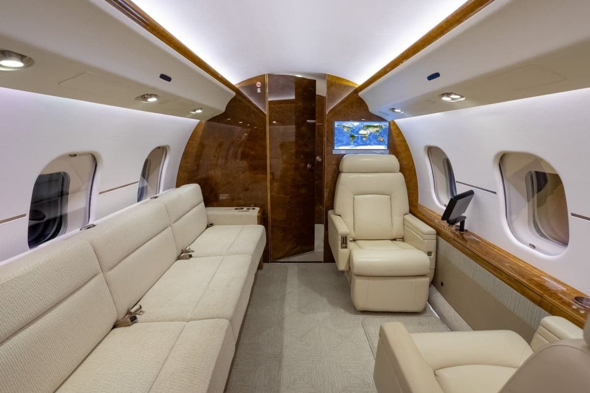 A view of the aircraft's interior with cream-colored leather seats and a couch.