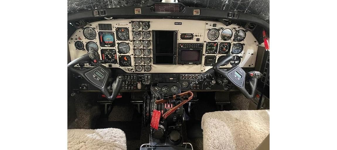 View of the aircraft cockpit with a full instrument panel.