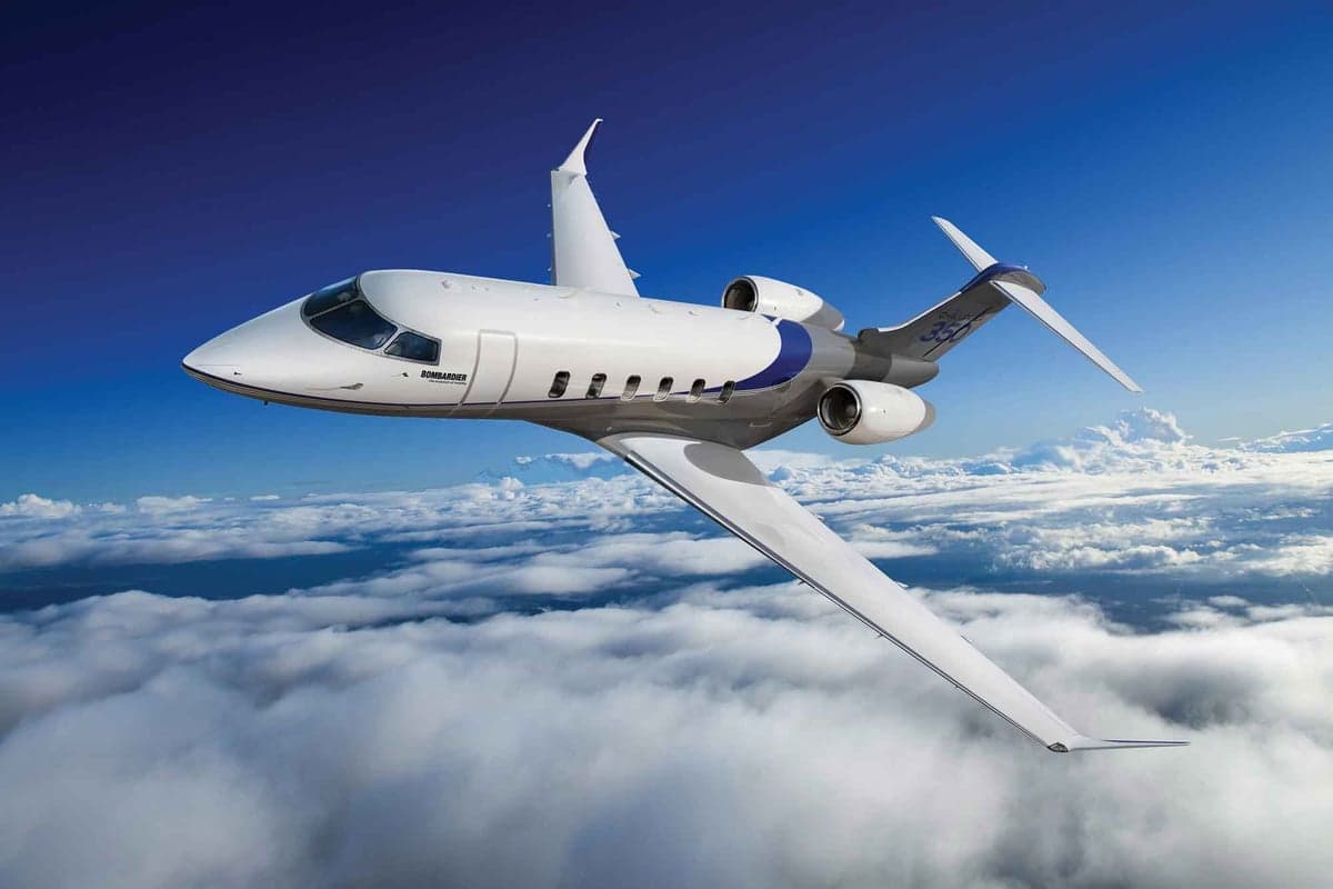 A Bombardier Challenger 350 flying above the clouds.
