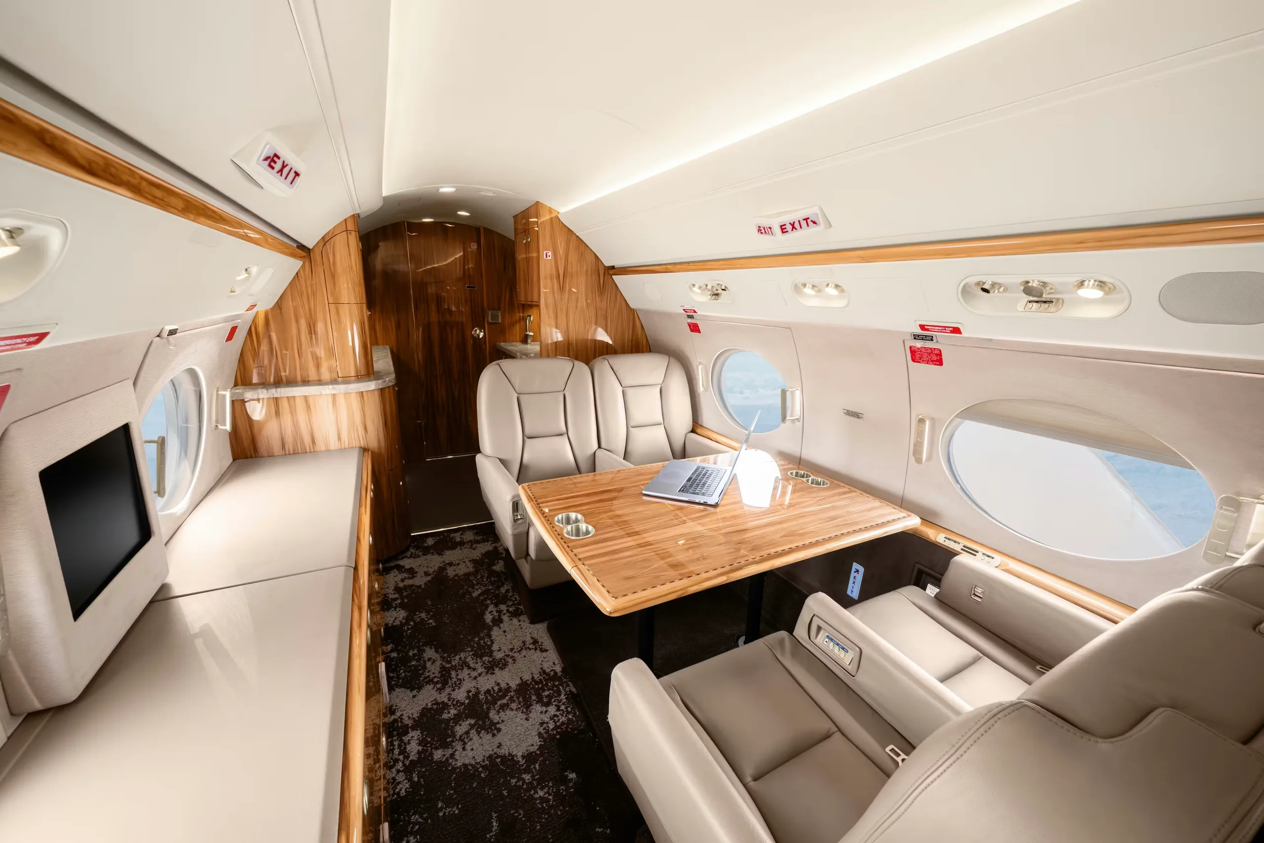 Interior view of the aircraft cabin with a table and leather seats.