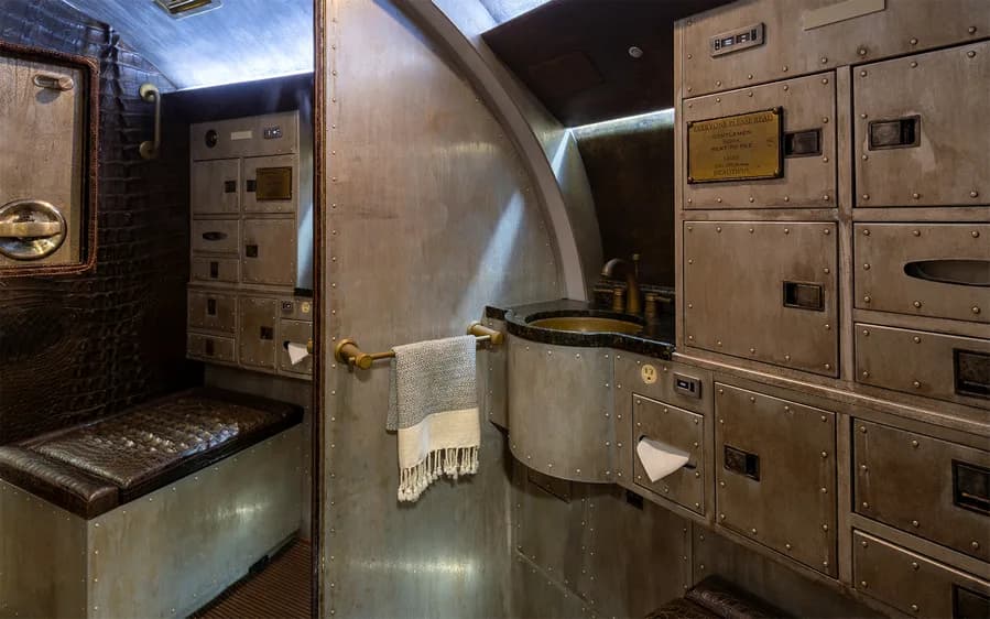Aircraft lavatory with a sink and storage cabinets.