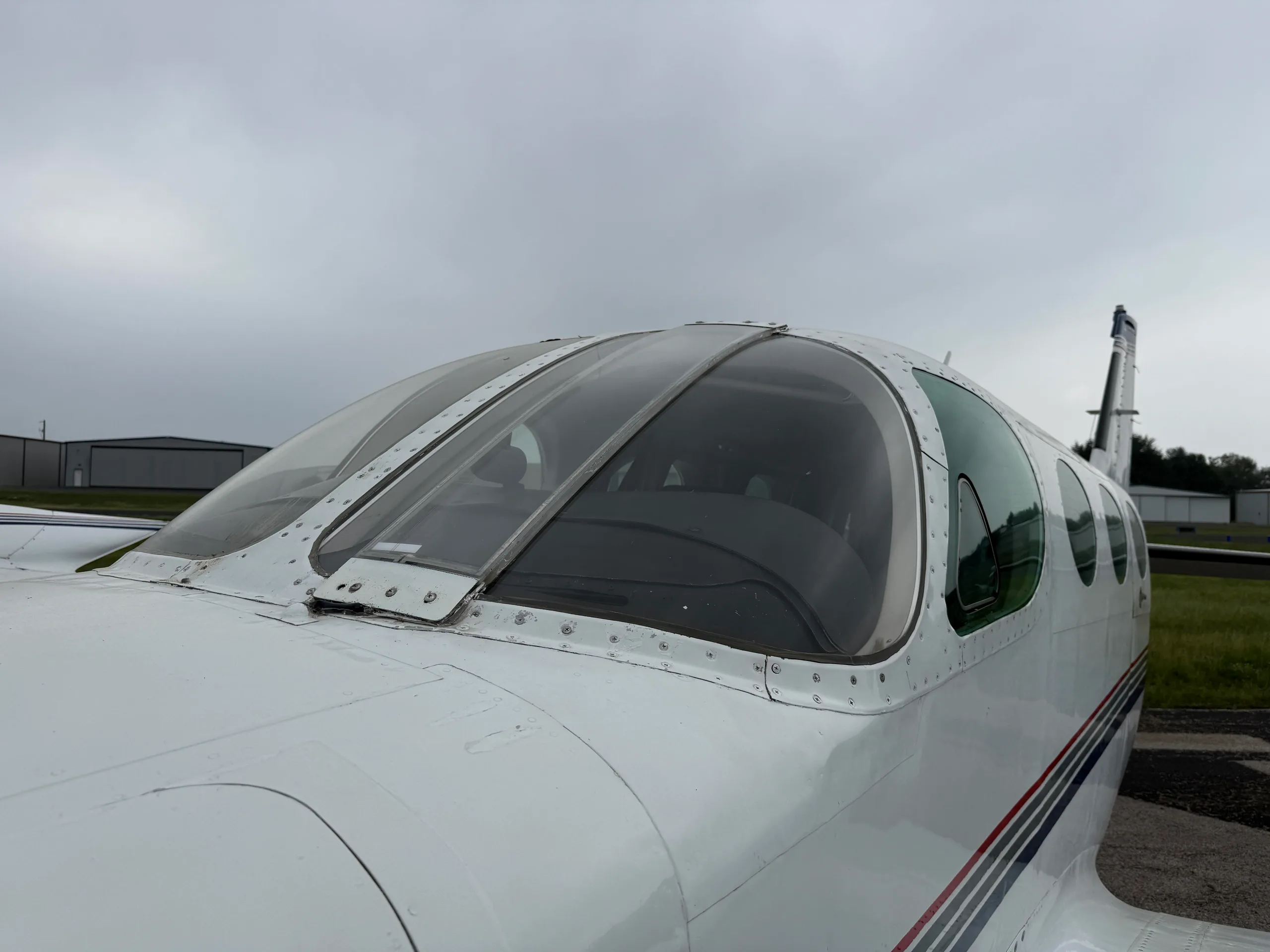 A close-up view of the front cockpit windows and upper fuselage of a white Cessna 335 aircraft.
