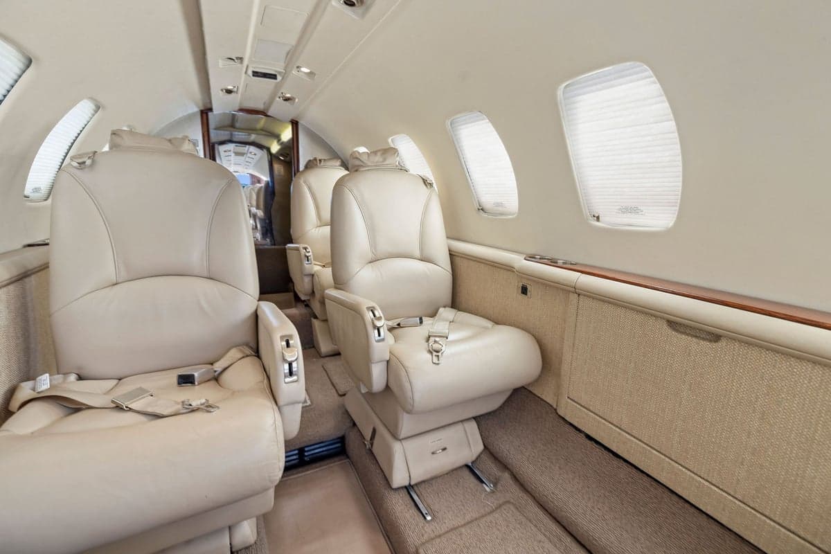 The aircraft's interior features individual leather seats and carpet.