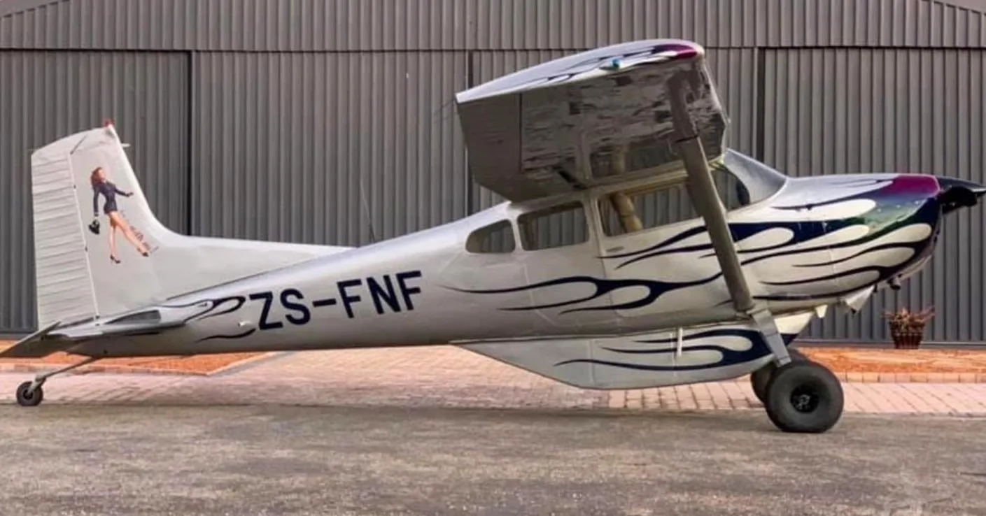 A Cessna 182 with a custom paint scheme and registration ZS-FNF is parked on the tarmac.