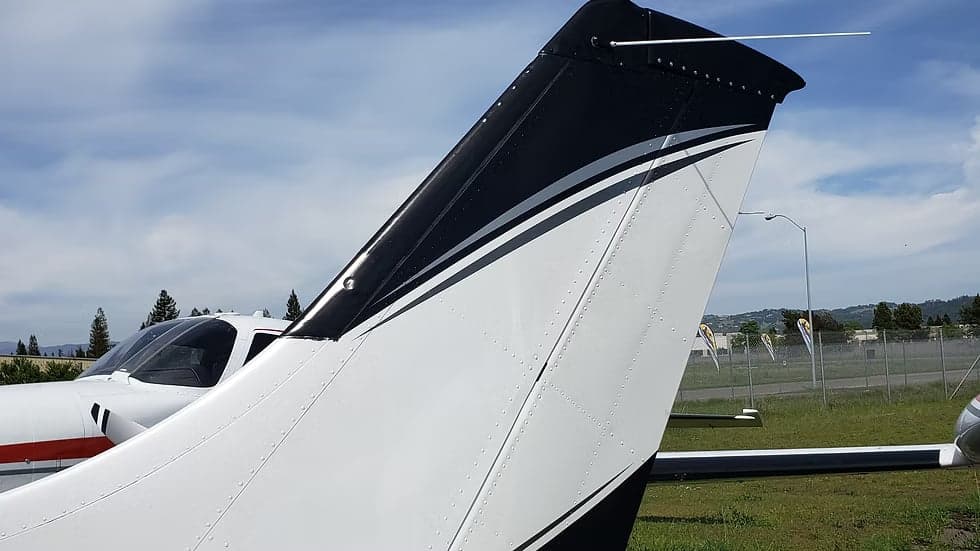 Close up of the tail of a black and white Cessna 208B Grand Caravan, registration N22VF.