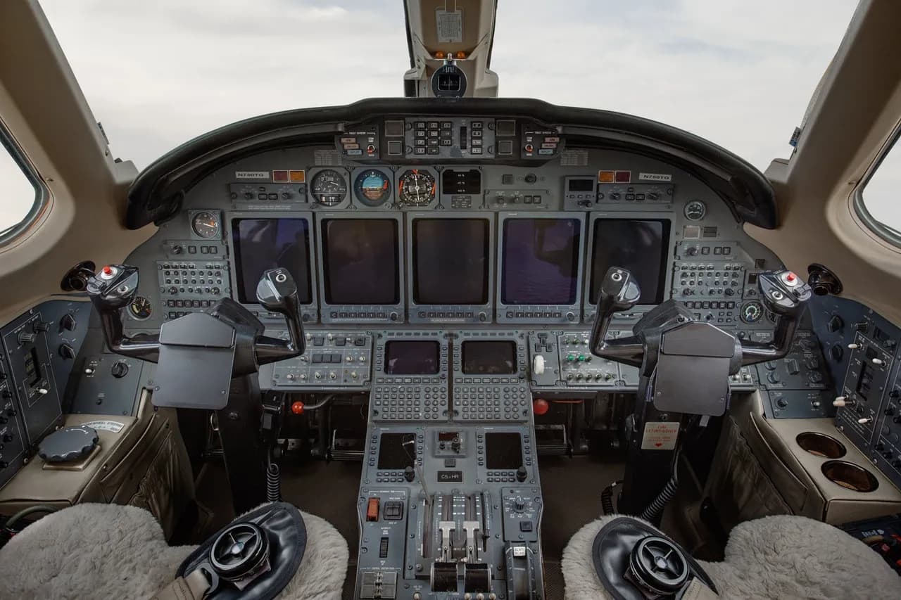 Aircraft cockpit with instrument panel and controls.