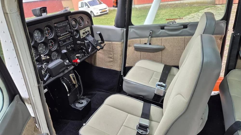 The front cabin of a Cessna Skyhawk II, showing the pilot and co-pilot seats and the instrument panel.