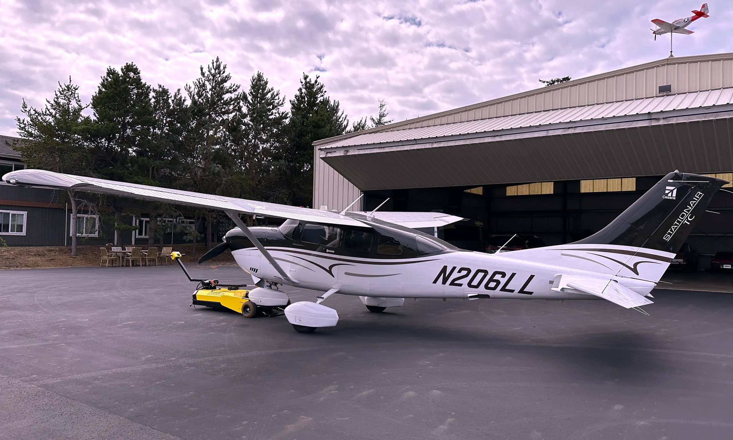 Cessna 206 Stationair aircraft N206LL parked outside a hangar.