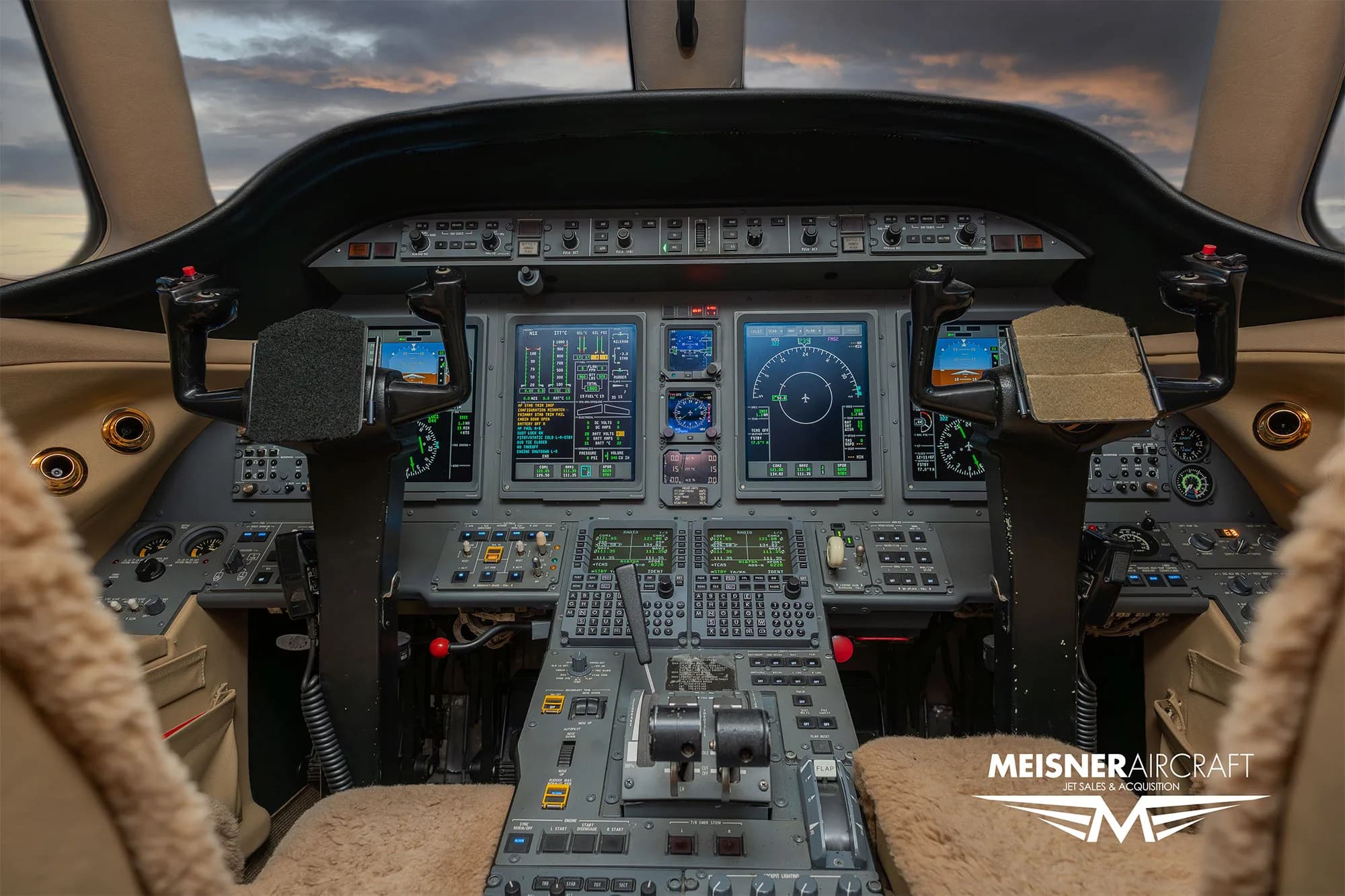 The cockpit of a modern business jet, featuring multiple digital displays and control panels.