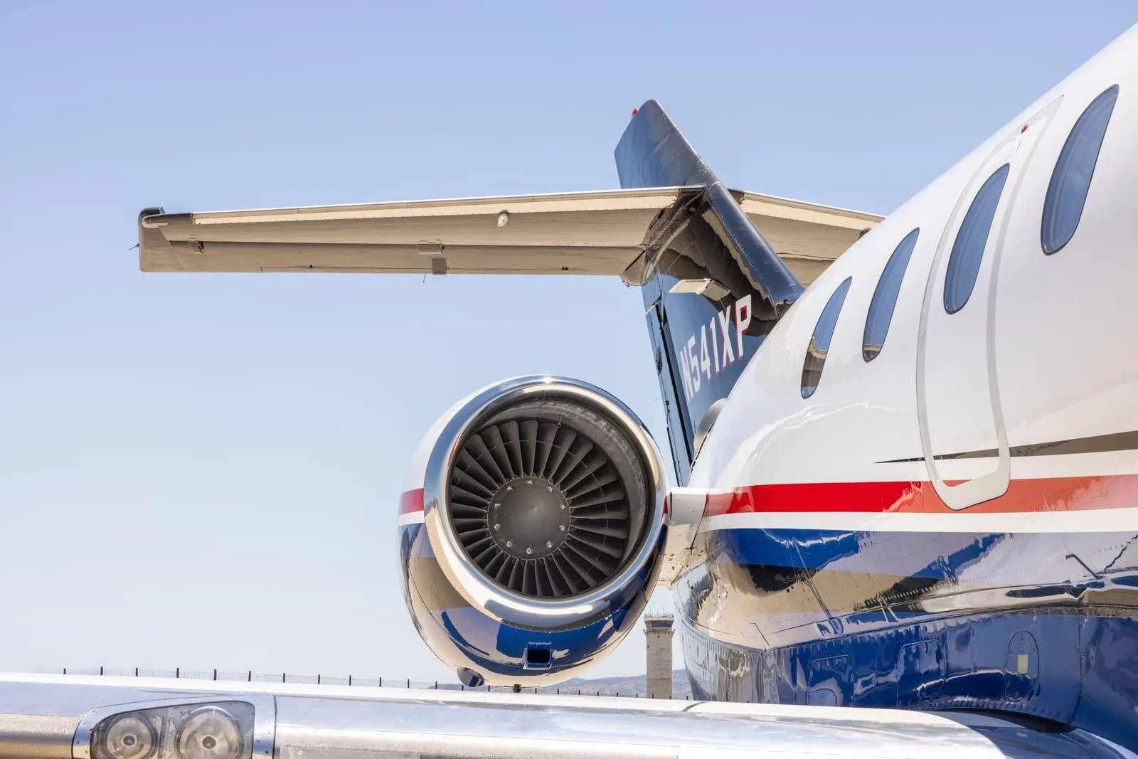 A close-up view of the tail and engine of the Hawker 800XP (N541XP) showing its blue and red livery.