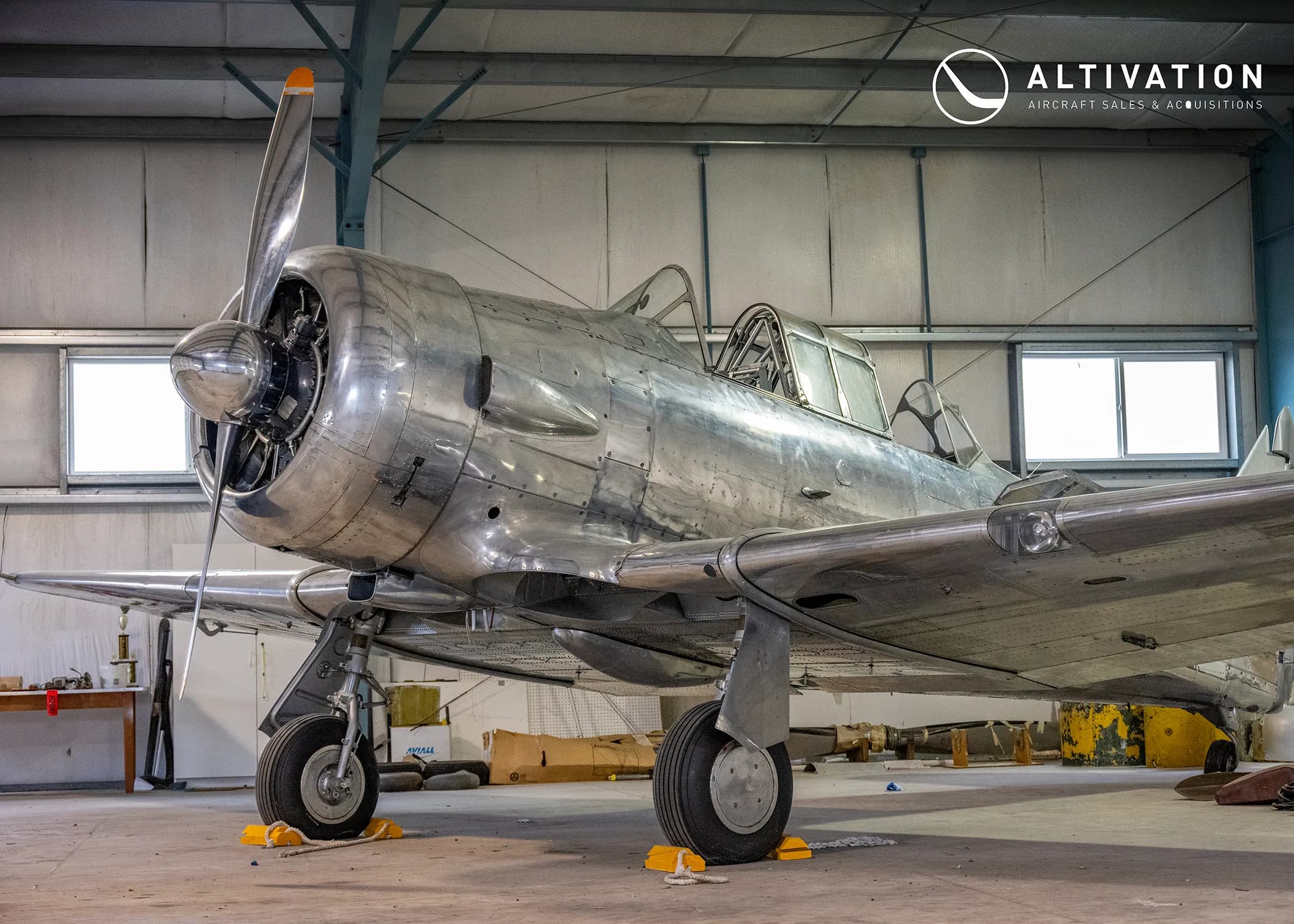 A silver aircraft in a hangar.